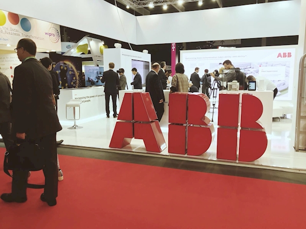 Conference attendees walk past an ABB Ltd booth.