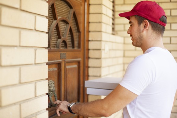 Pizza delivery man ringing a doorbell