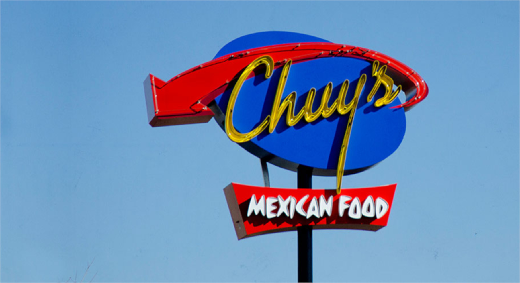 Roadside sign showing the Chuy's logo and the text "Mexican food."