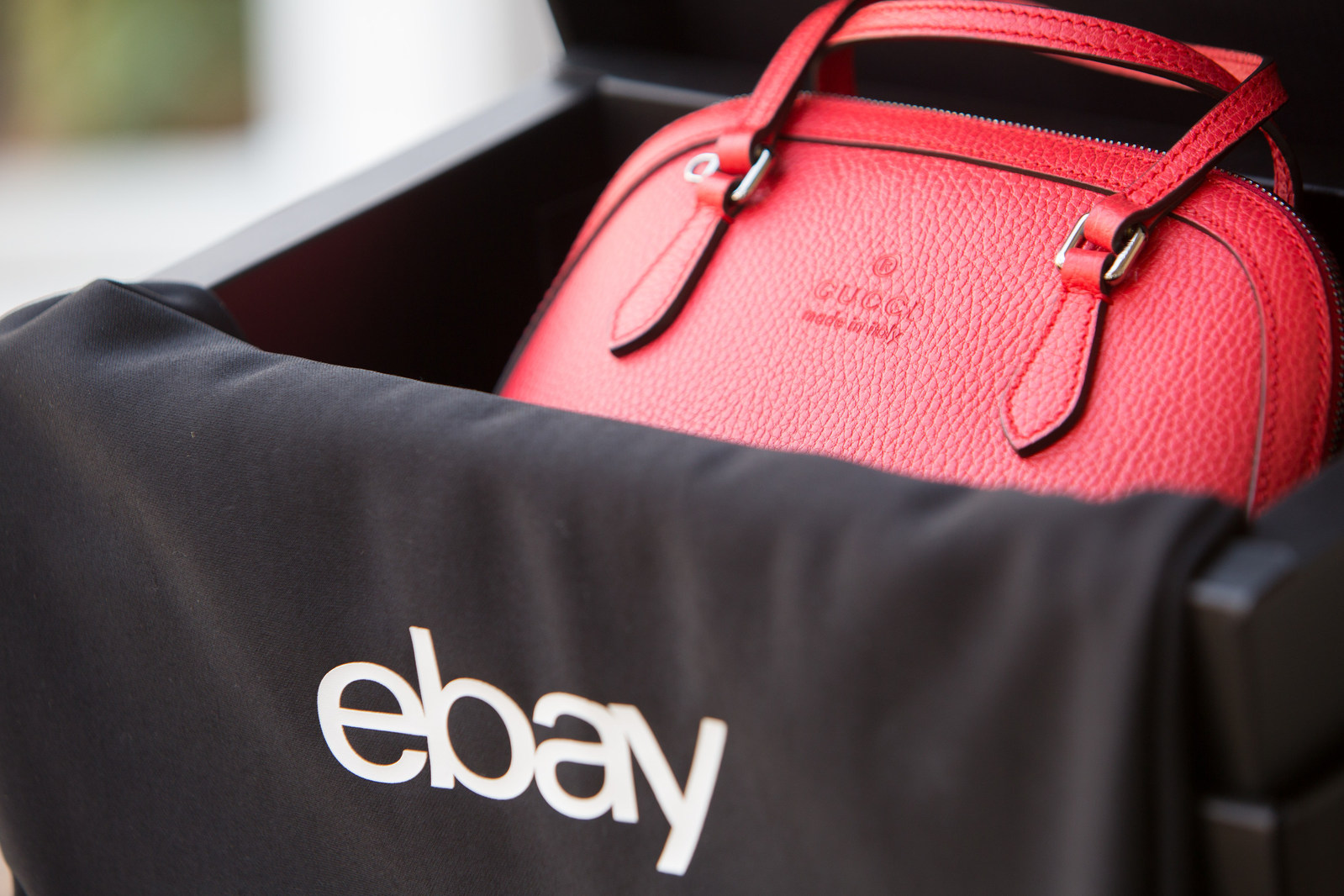 A handbag sits in a box labelled "ebay."