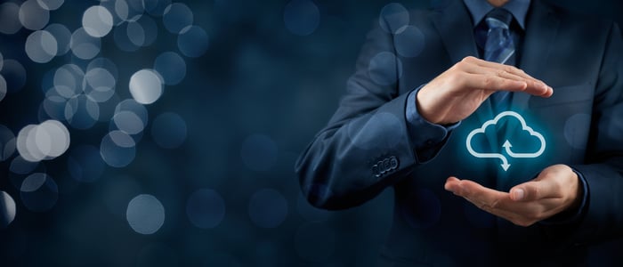 Man holding an illustration of cloud computing between his hands