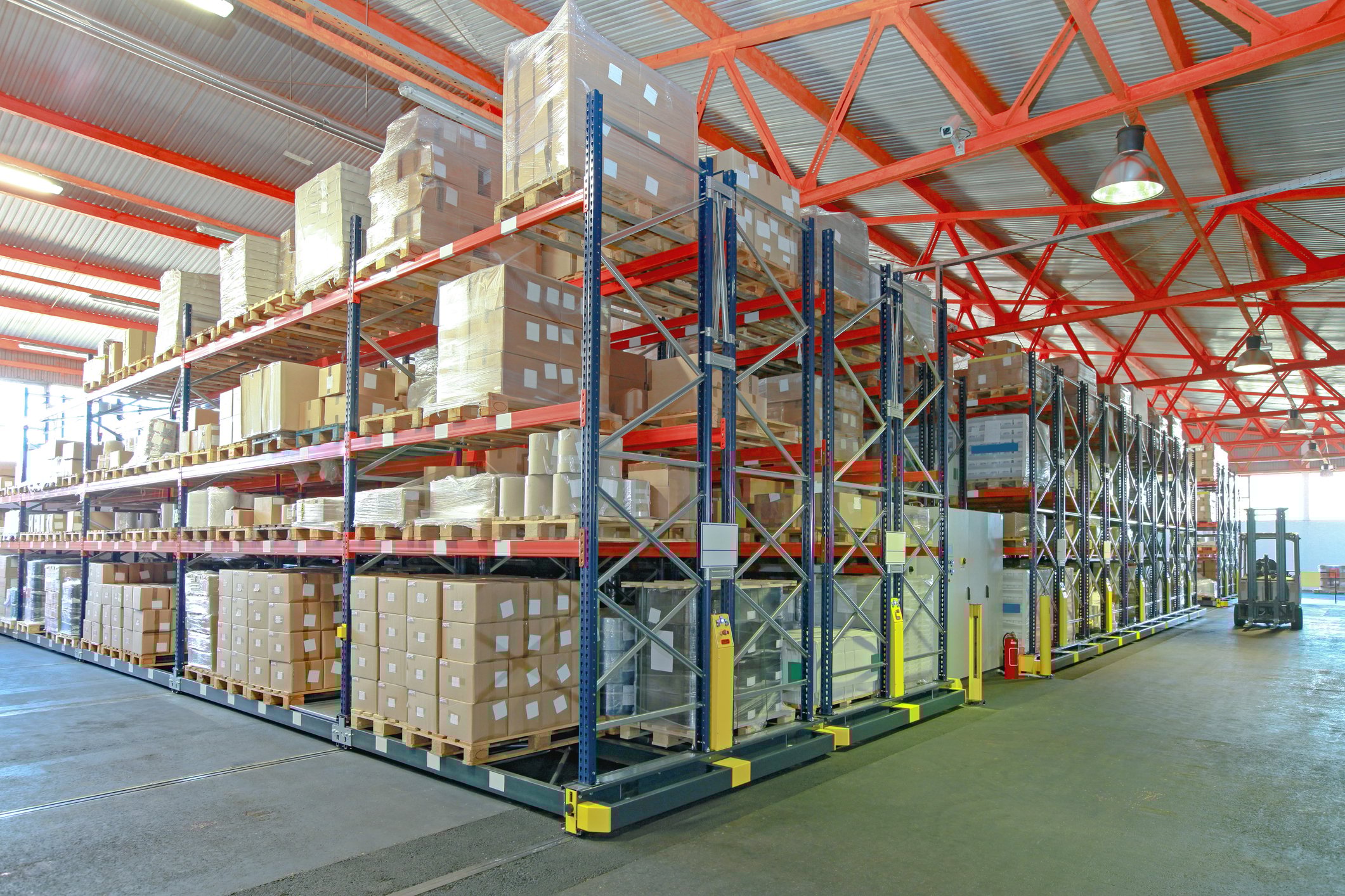 Warehouse with boxes and a forklift picking pallets. 