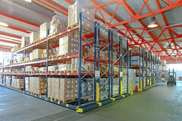 Warehouse with boxes and a forklift picking pallets. 