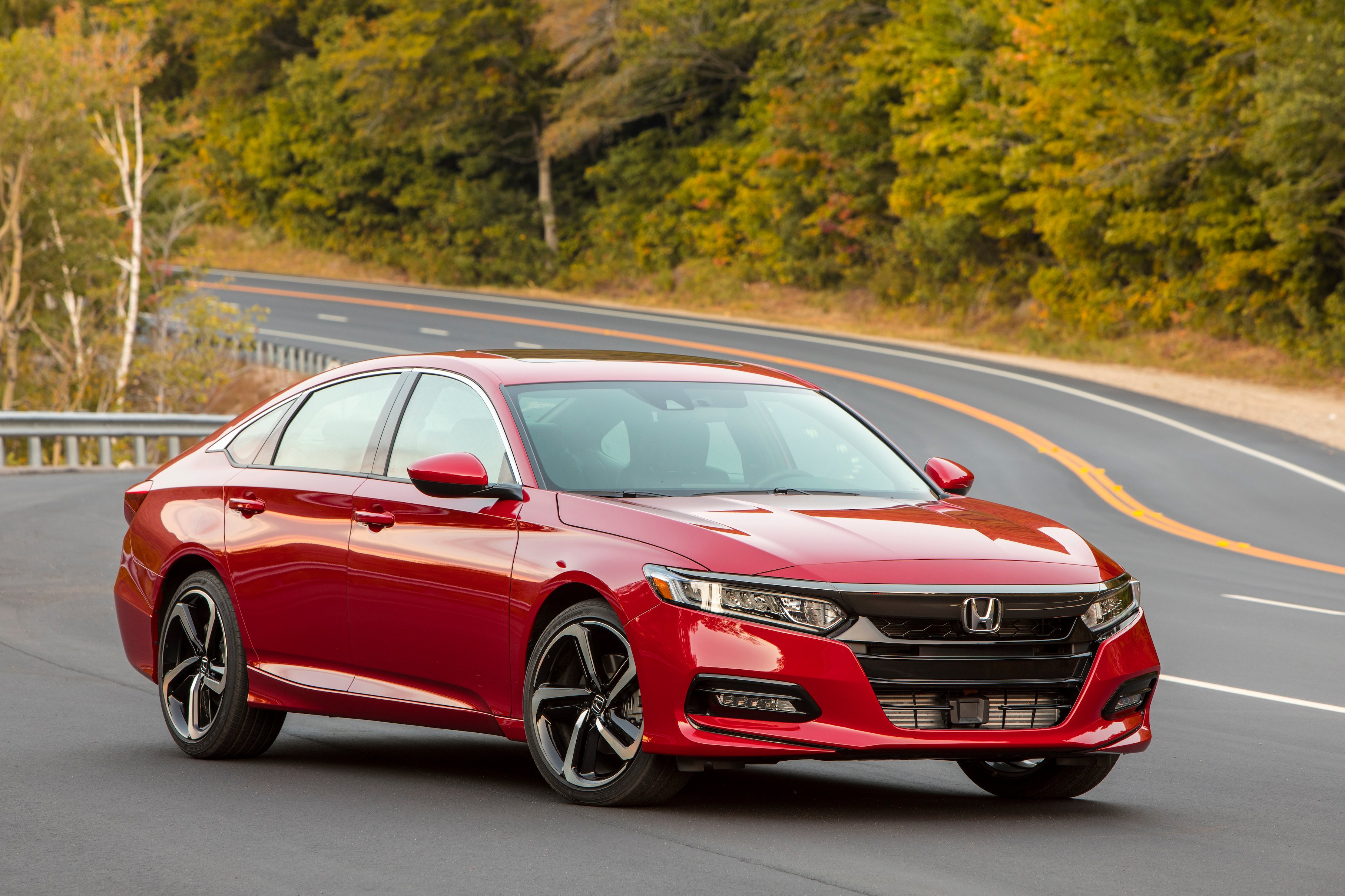 A red 2018 Honda Accord, a midsize sedan with a hatchback-like roofline, on a country road.