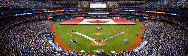 The inside of Rogers Centre, home of the Toronto Blue Jays baseball team. The Canadian flag with the red maple leaf is being displayed across the outfield.
