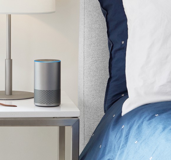 An Amazon Echo sitting on a nightstand.