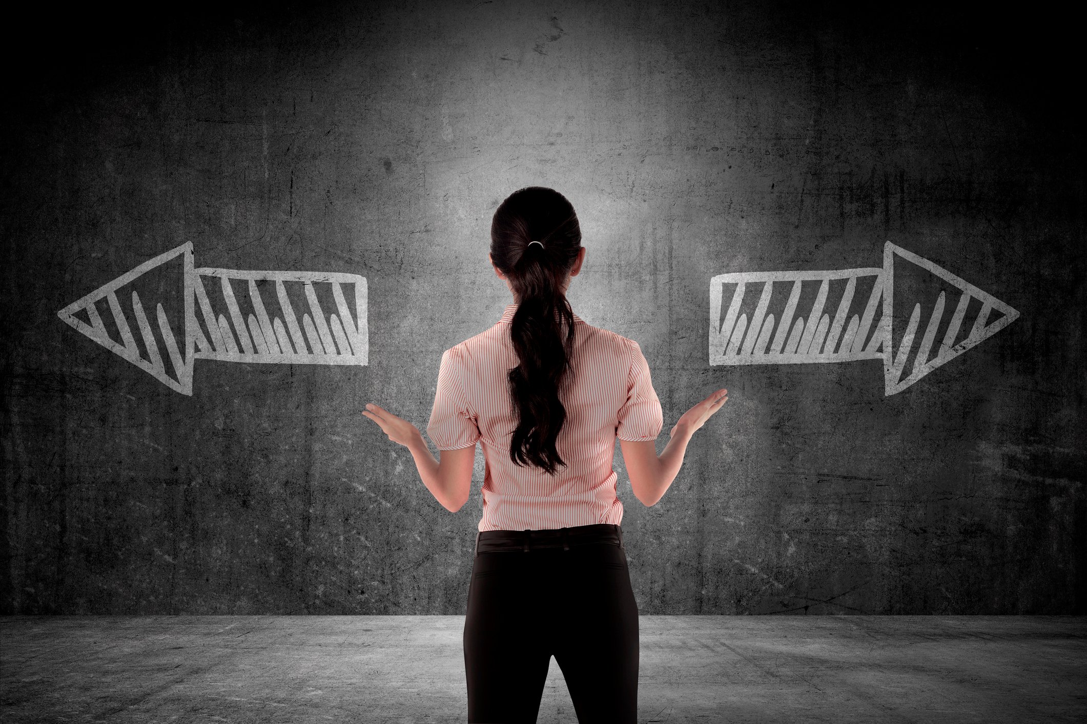 Woman facing wall with arrows pointing left and right