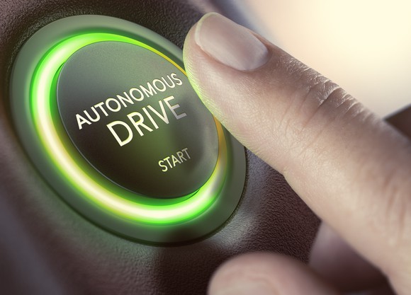 Finger pushing a button that says "autonomous drive start"
