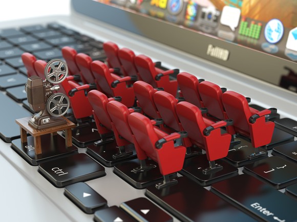 Rows of tiny movie seats placed on a laptop keyboard. 