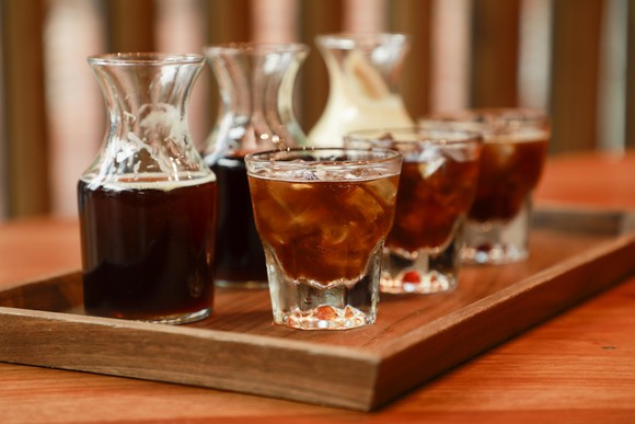 Three decanters and glasses filled with cold-brew coffee