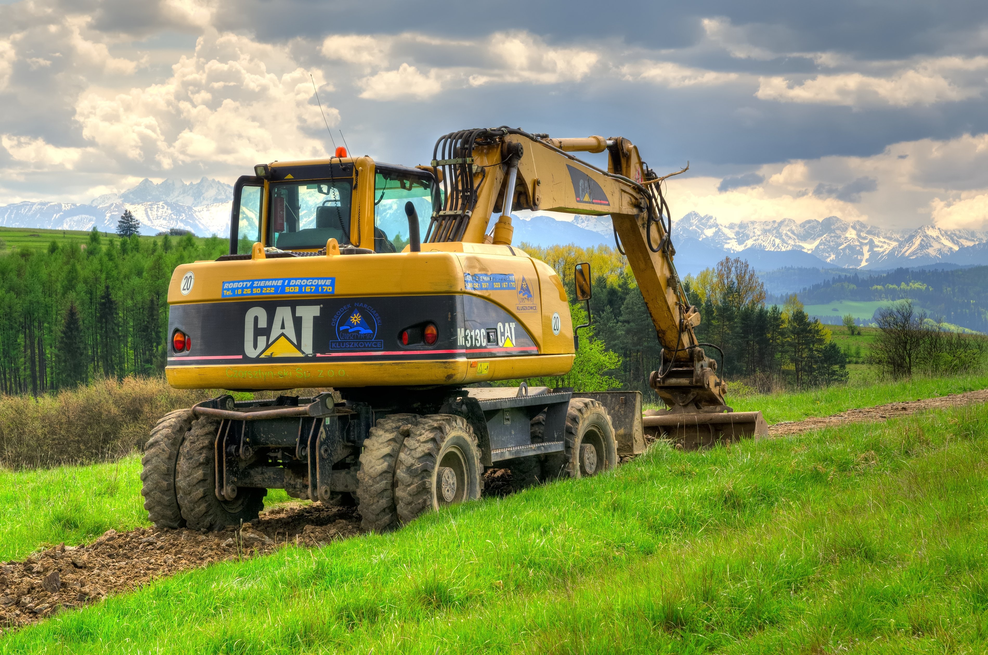 a caterpillar excavator going through a field