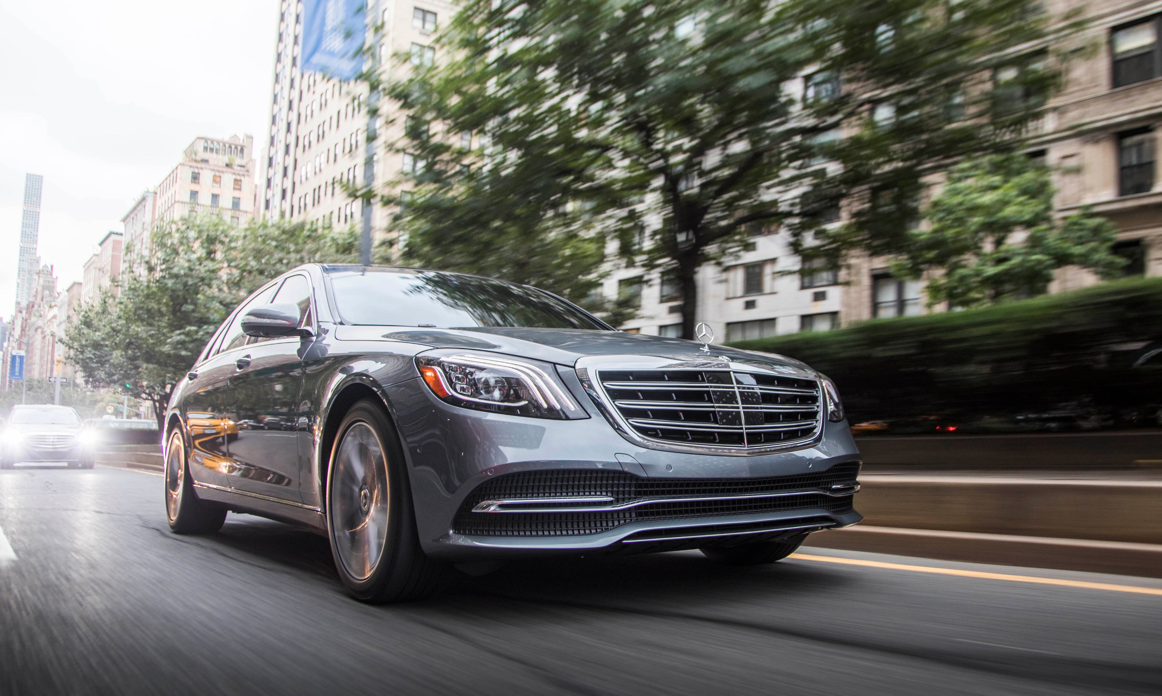 A silver 2018 Mercedes-Benz S450, a big four-door luxury sedan, on a city street.