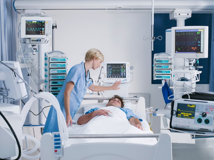 Nurse tending to patient in hopsital bed