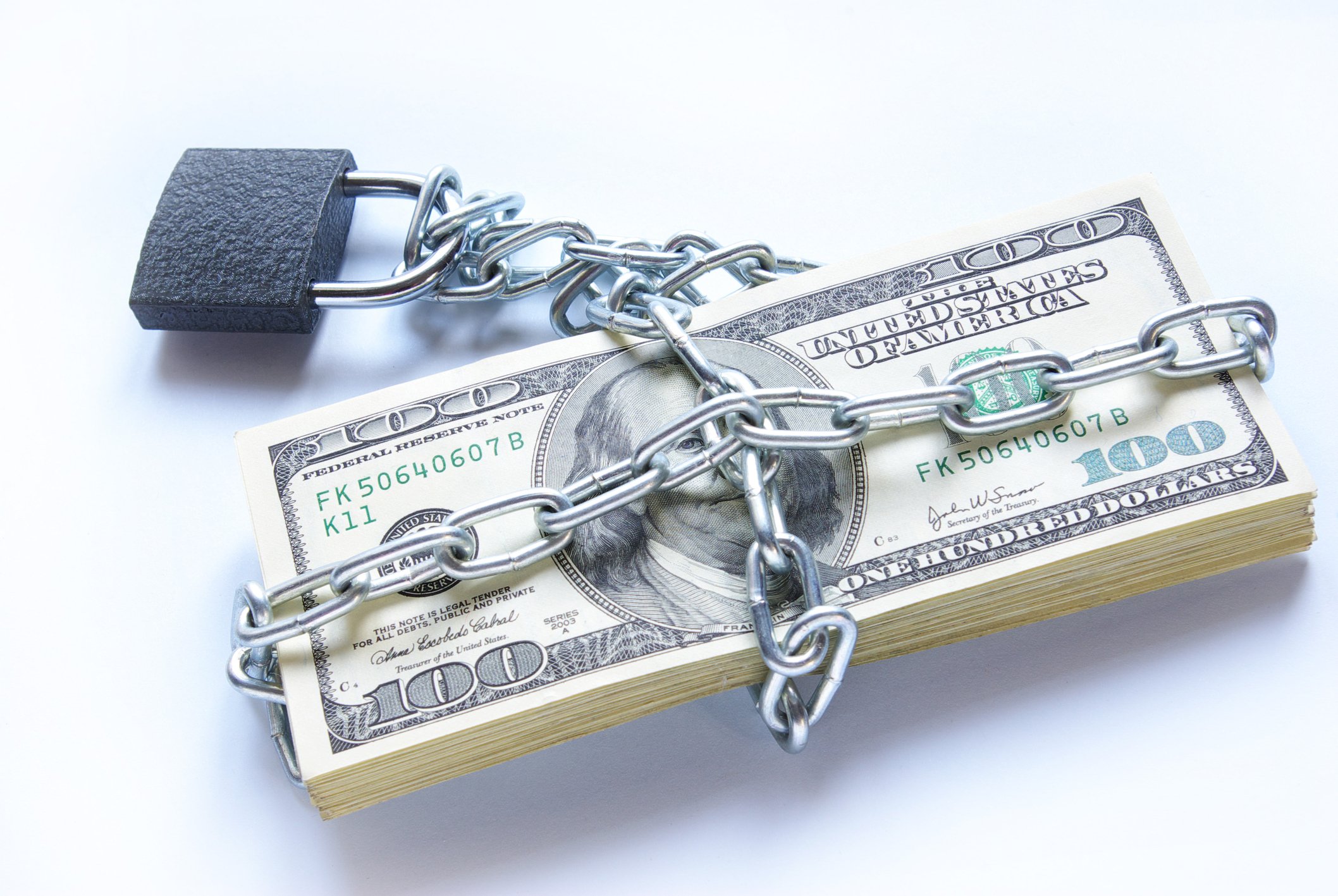 A stack of hundred dollar bills bound by chains and a lock.