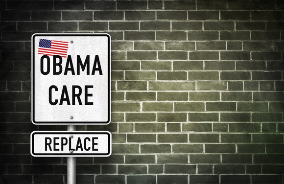 A street sign reading: "Obamacare, Replace," with an American flag on it