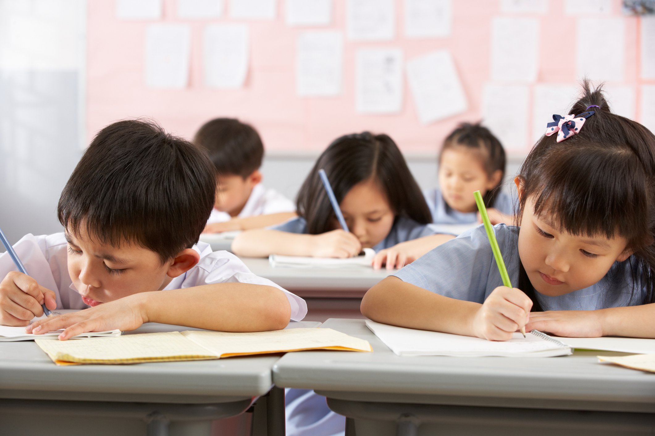 Chinese students working on schoolwork in a classroom.