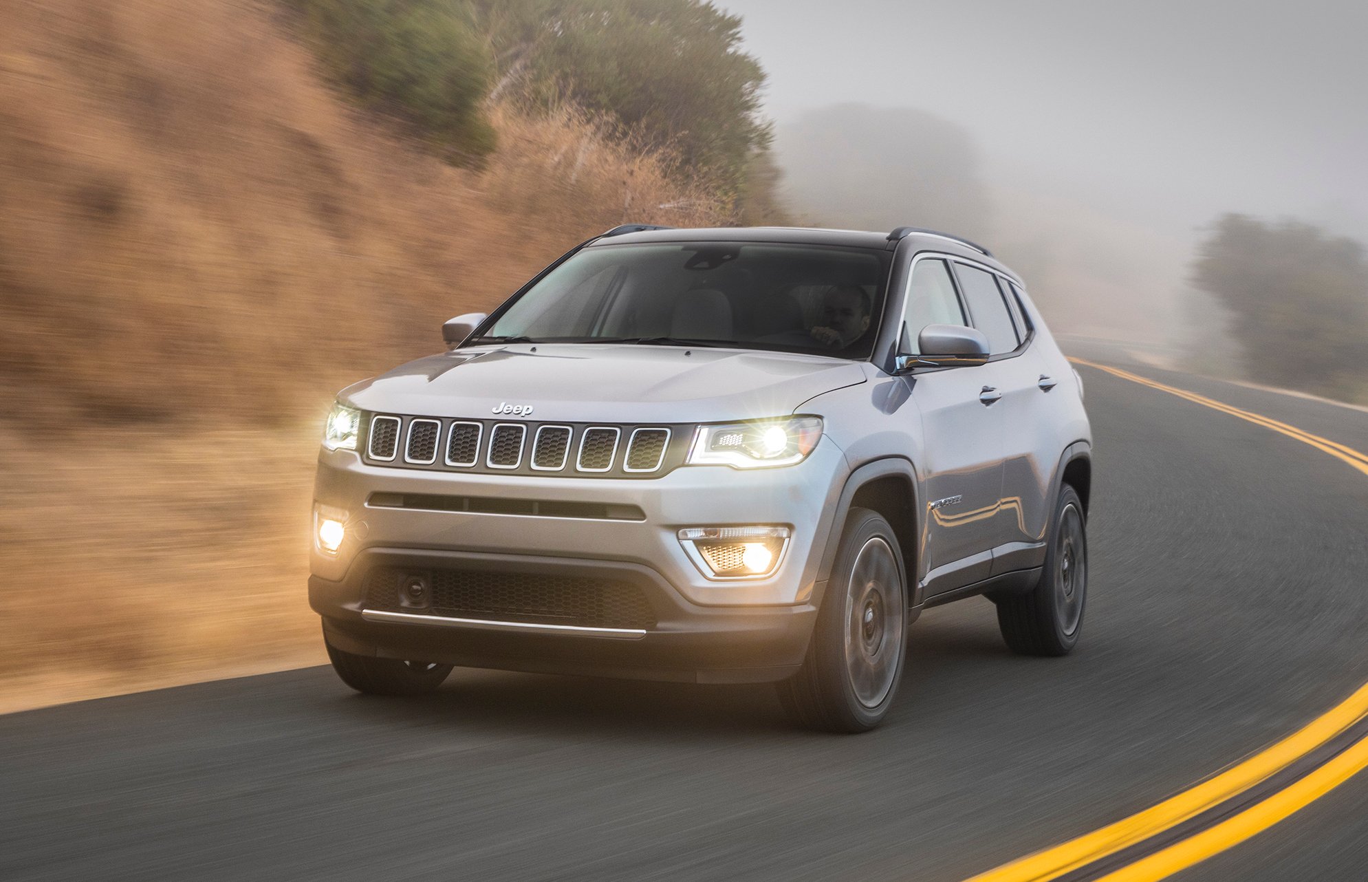 A silver 2017 Jeep Compass, a compact SUV, on a mountain road.