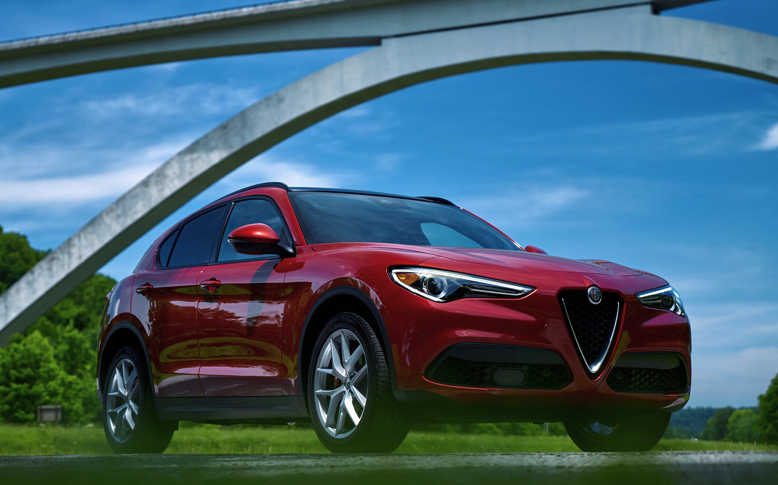 A red 2018 Alfa Romeo Stelvio, a compact luxury SUV.