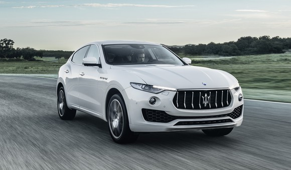 A white Maserati Levante, a midsize luxury SUV, on a country road.