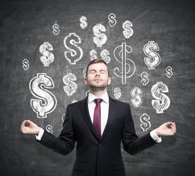 Man meditating in front of dollar sign getty