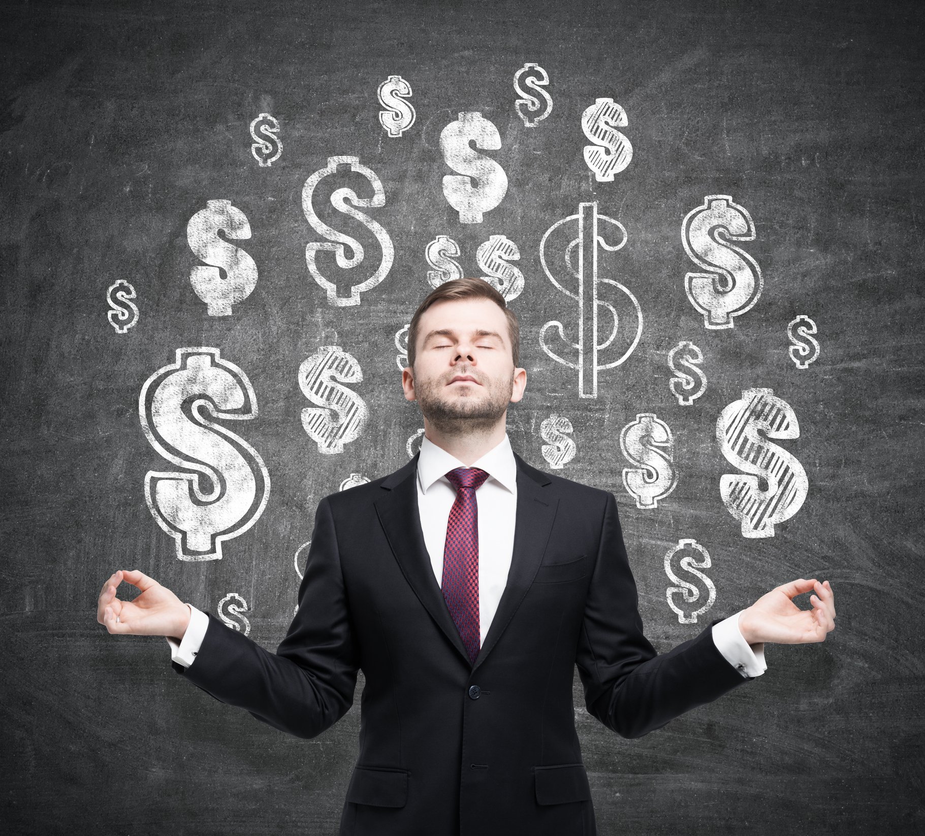 Man meditating in front of dollar signs