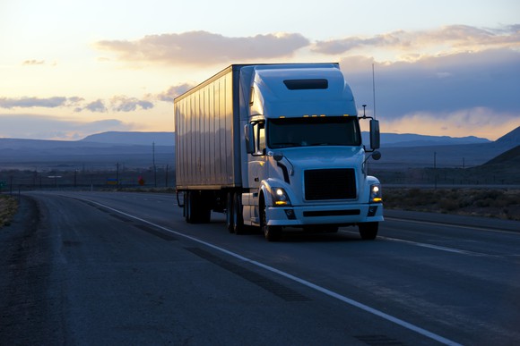 Semi-truck on highway at dusk.