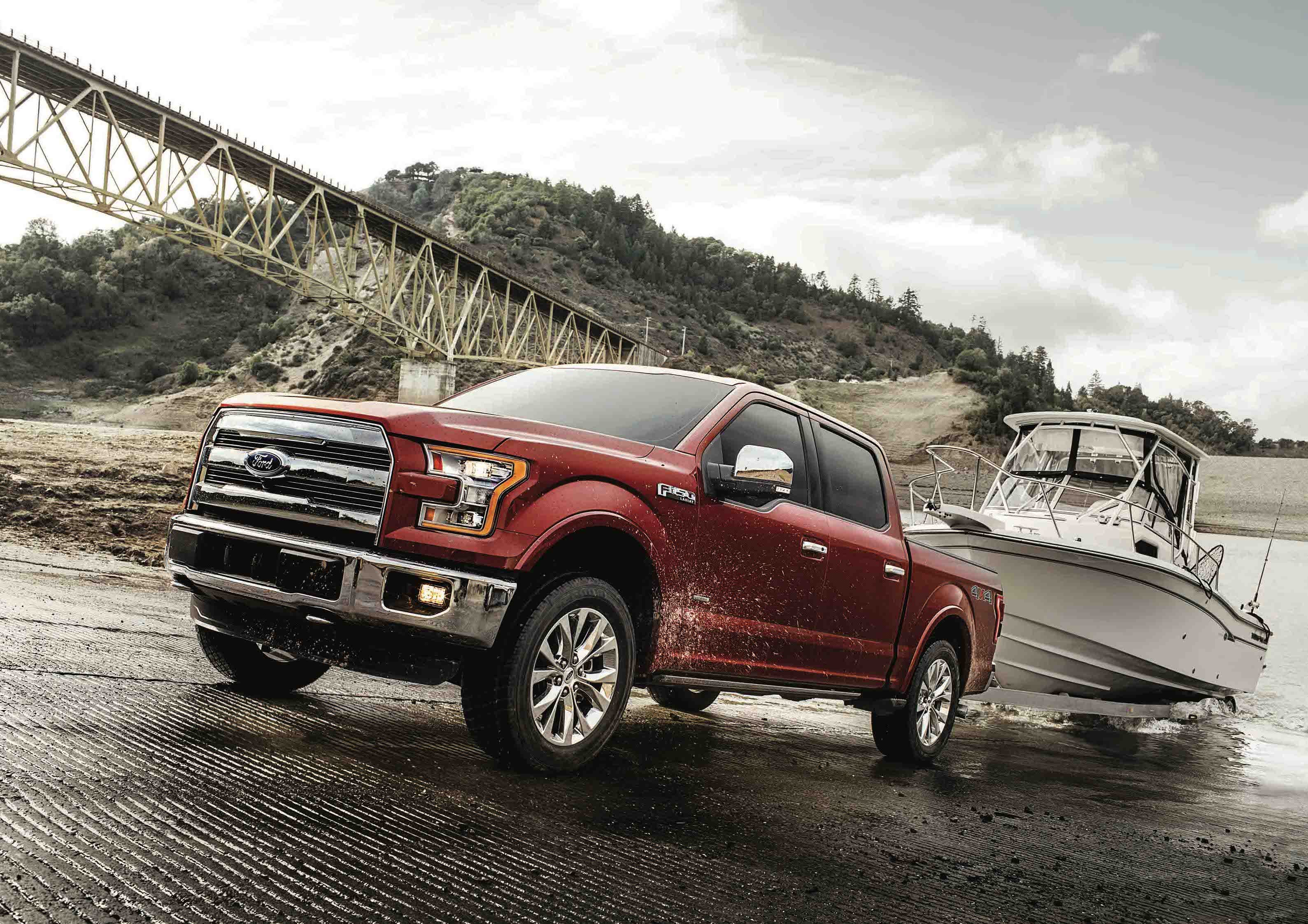 A red 2017 Ford F-150 pickup towing a boat trailer.