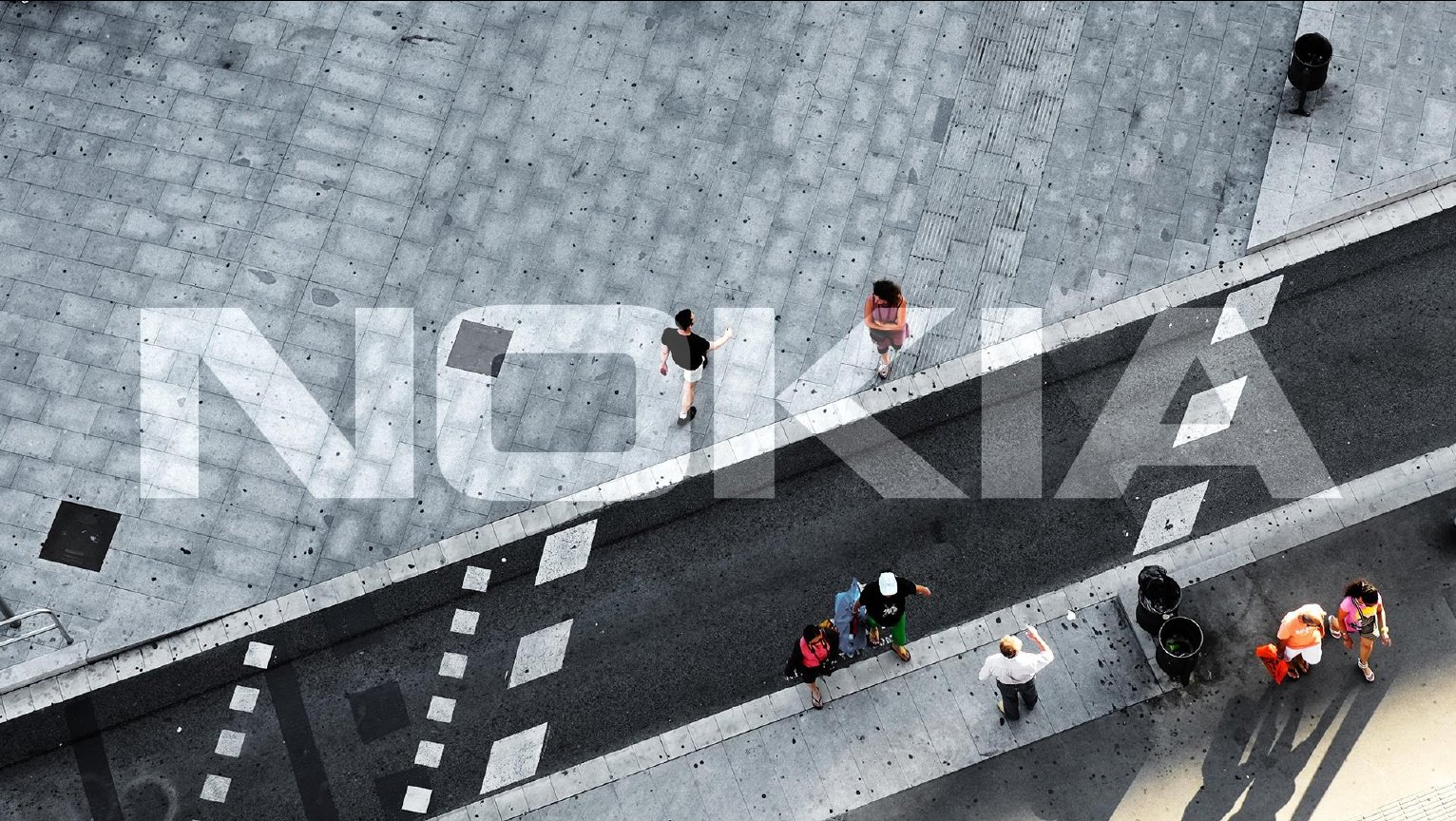 Bird's-eye view of a lightly crowded city street, overlaid with a transparent Nokia logo.