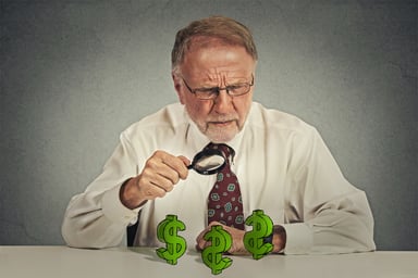 Senior Magnifying Glass Dollar Signs Getty