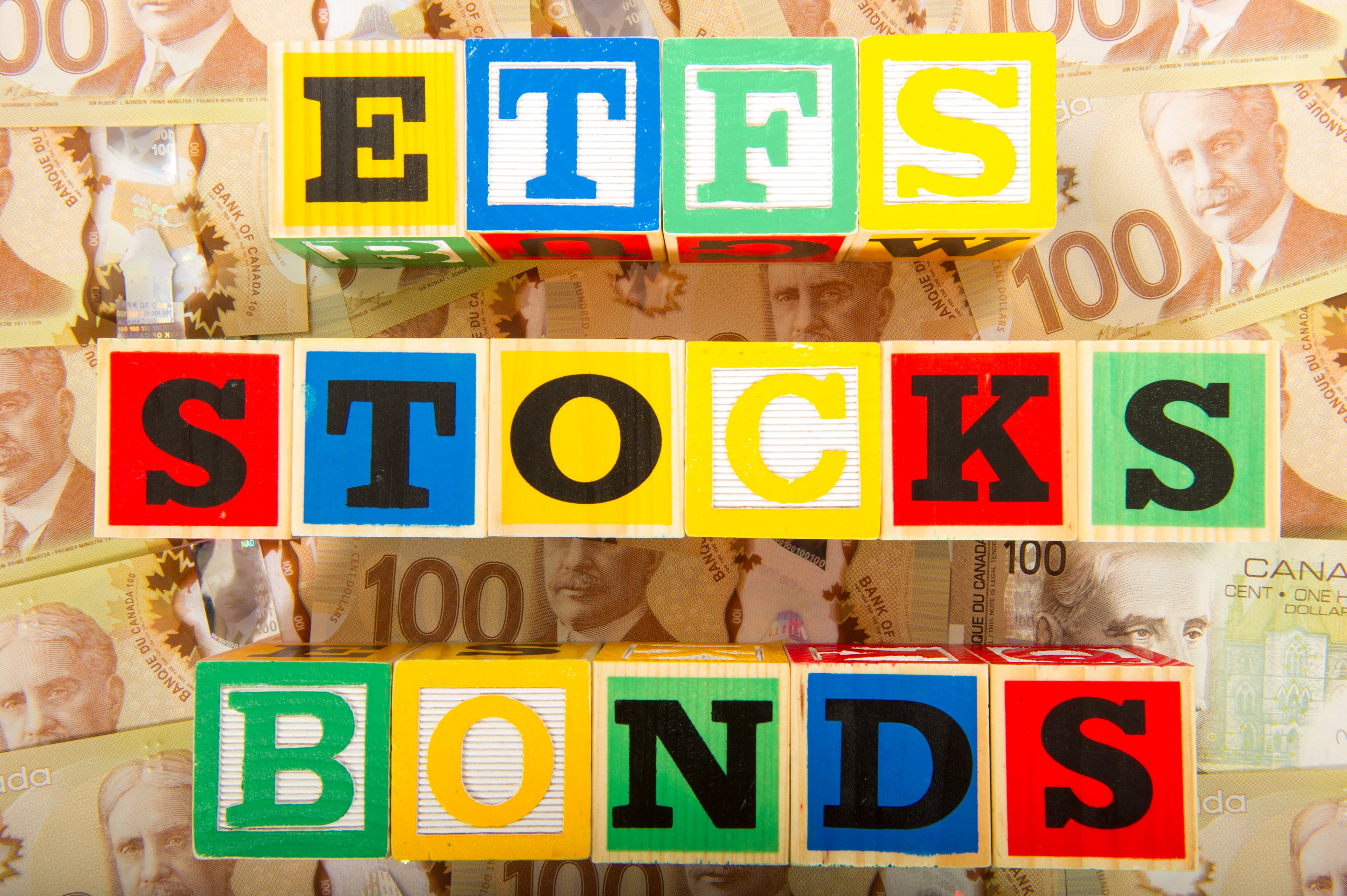 Building blocks with the words ETFS, STOCKS, and BONDS printed on them