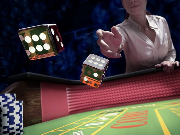 Woman rolling dice into a gaming table.