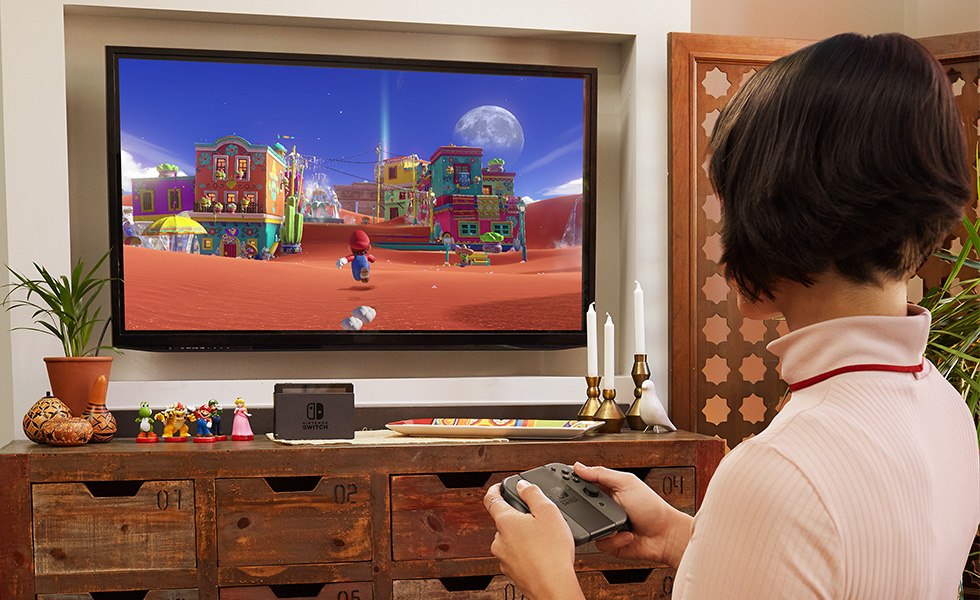 A youngster playing Mario Odyssey on a Nintendo Switch system, in this case connected to a big-screen TV.