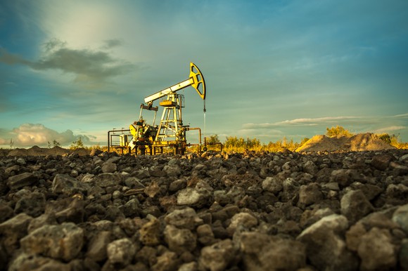 An oil pump with large rocks in the foreground.