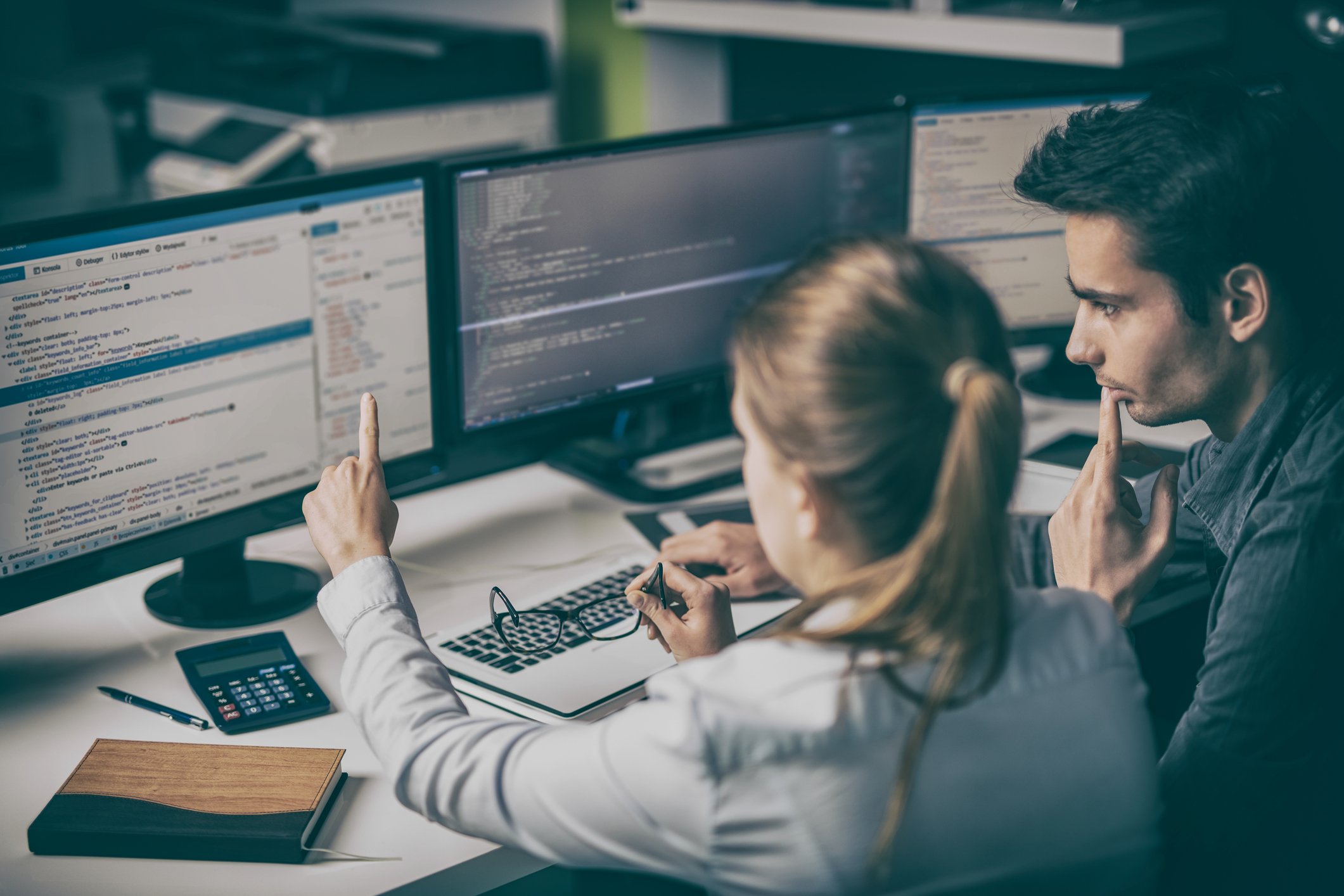 A man and a woman cluster over a computer screen.