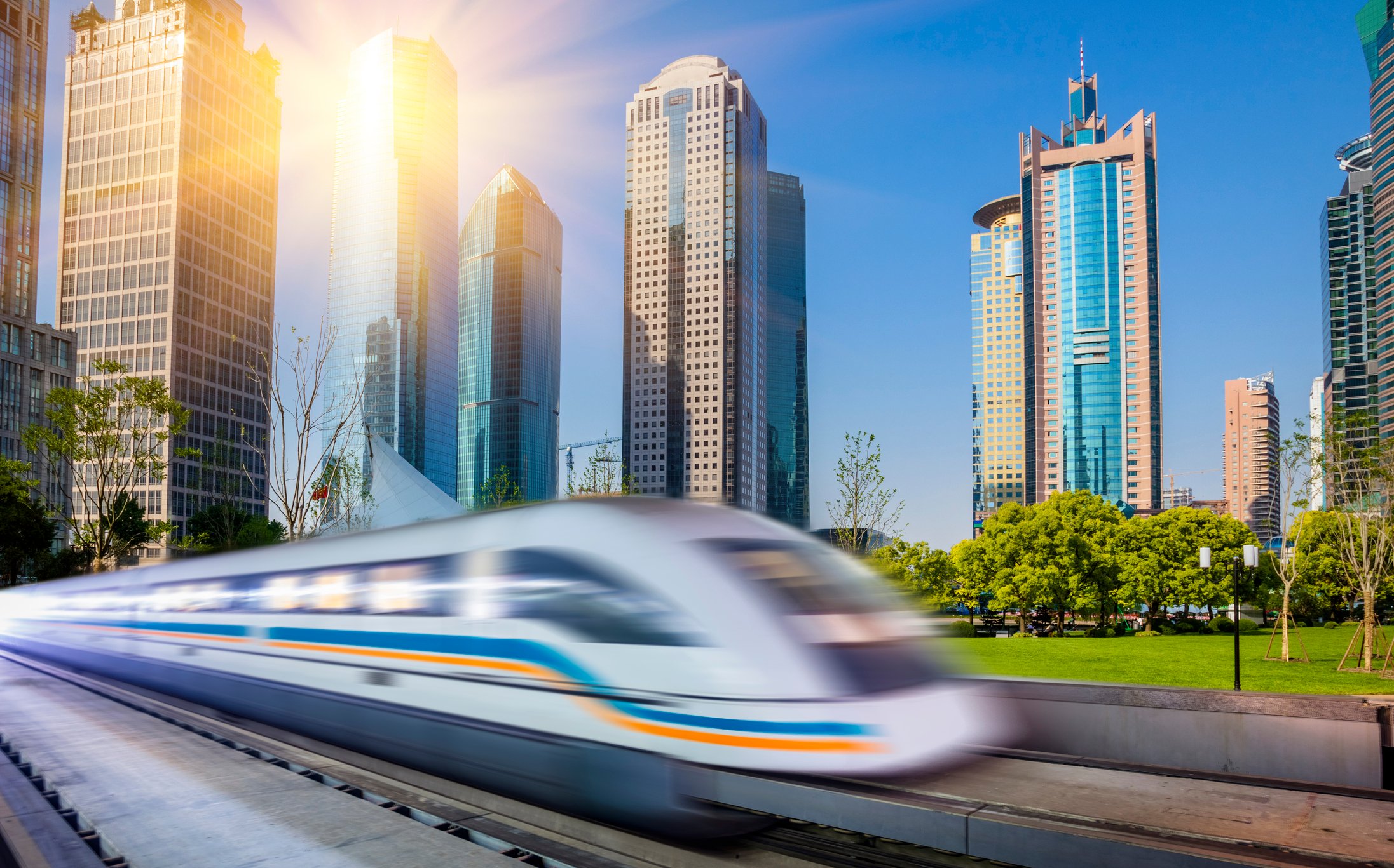 A commuter train in Shanghai passing tall buildings