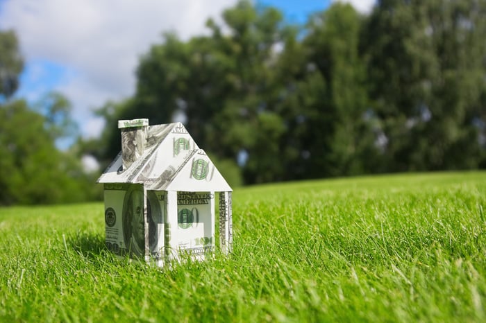 A small home built of paper money.