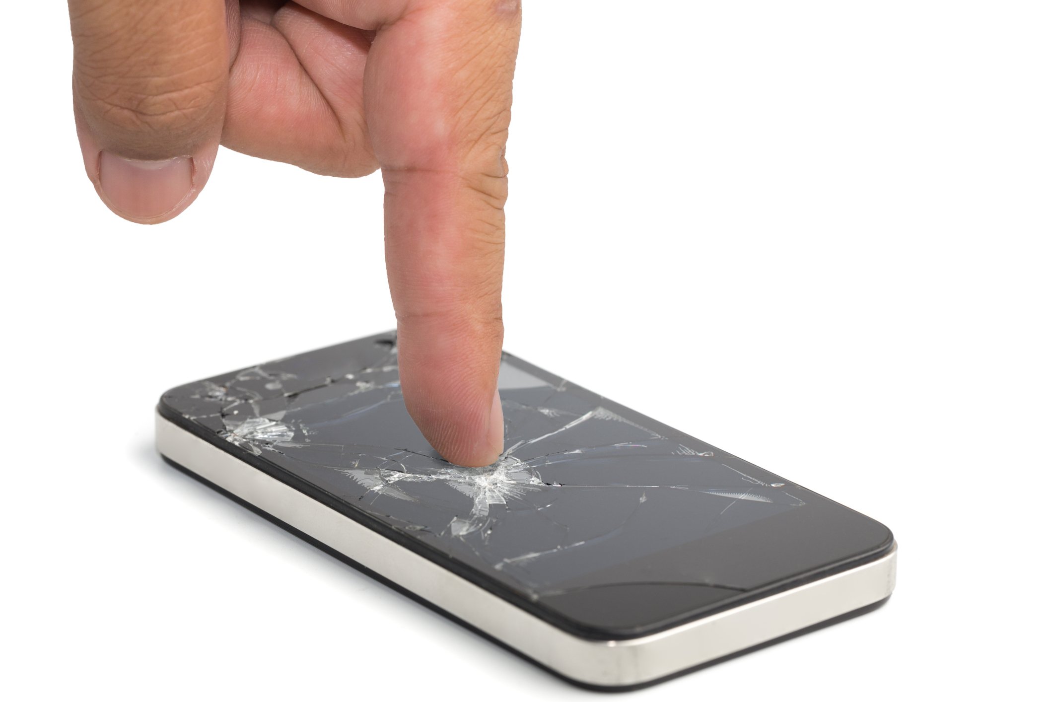 Index finger pushing down on a broken smartphone screen.