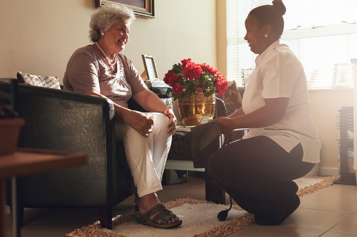 A nurse and her elderly patient in a senior housing facility