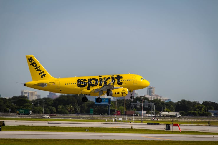 Exterior of landing Spirit A319 in bright yellow livery.