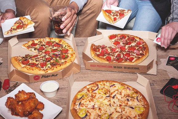 A group of people eating Pizza Hut at home