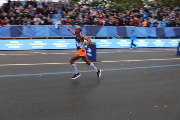 Meb Keflezighi coming down the stretch at the New York City marathon, waving to the crowd.