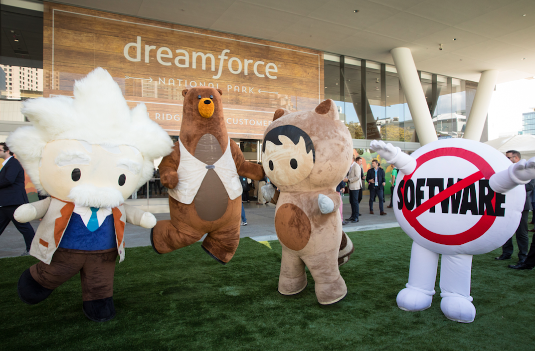 Four different mascots stand in front of a Dreamforce sign during Salesforce's 14th annual conference
