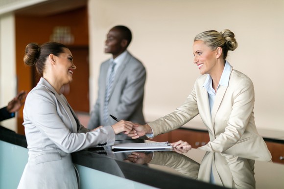 A person checks in at a hotel reception counter.