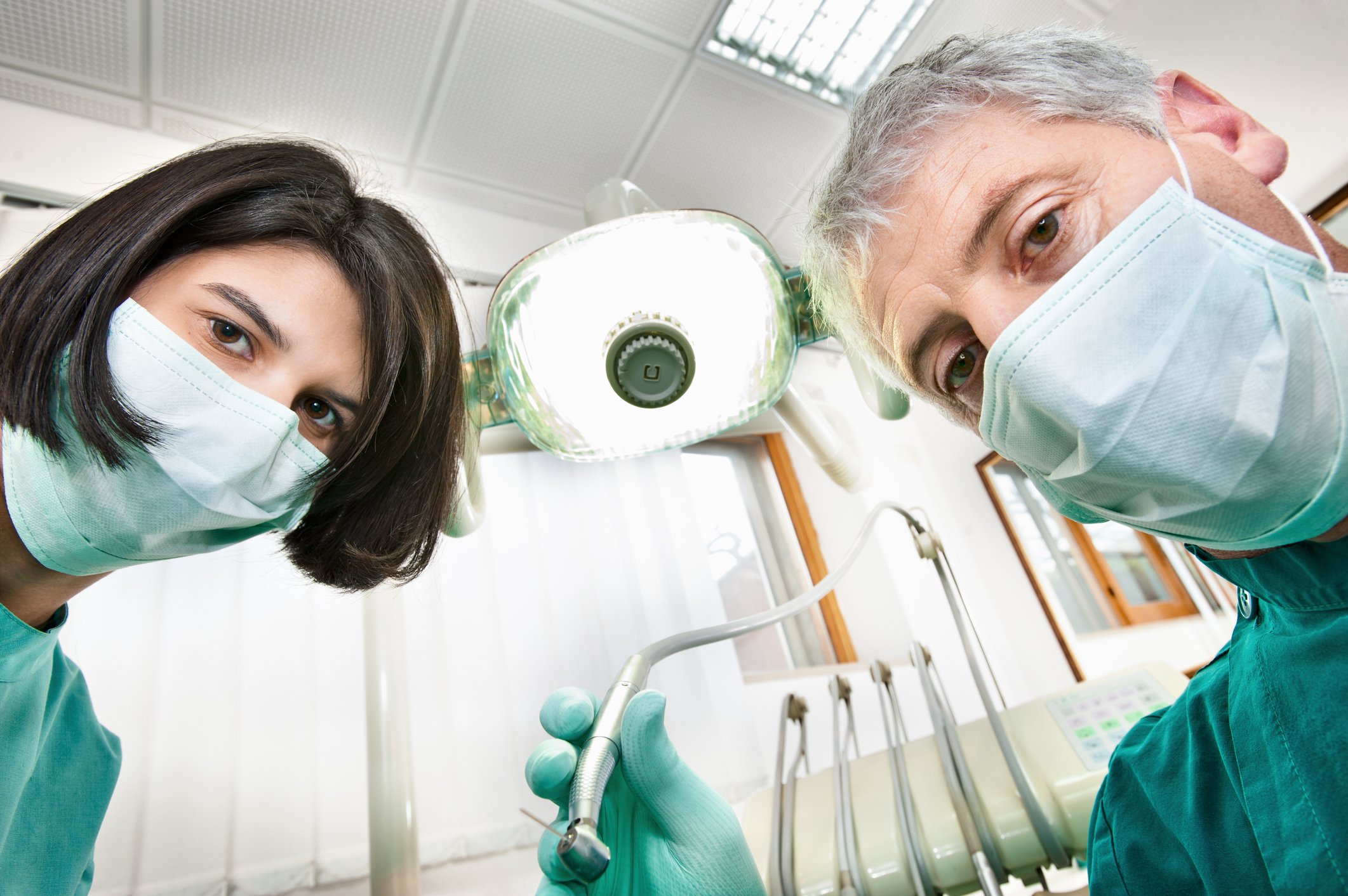 a dentist and his assistant looking into a camera