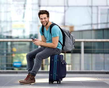 man sitting on suitcase_GettyImages-512522063