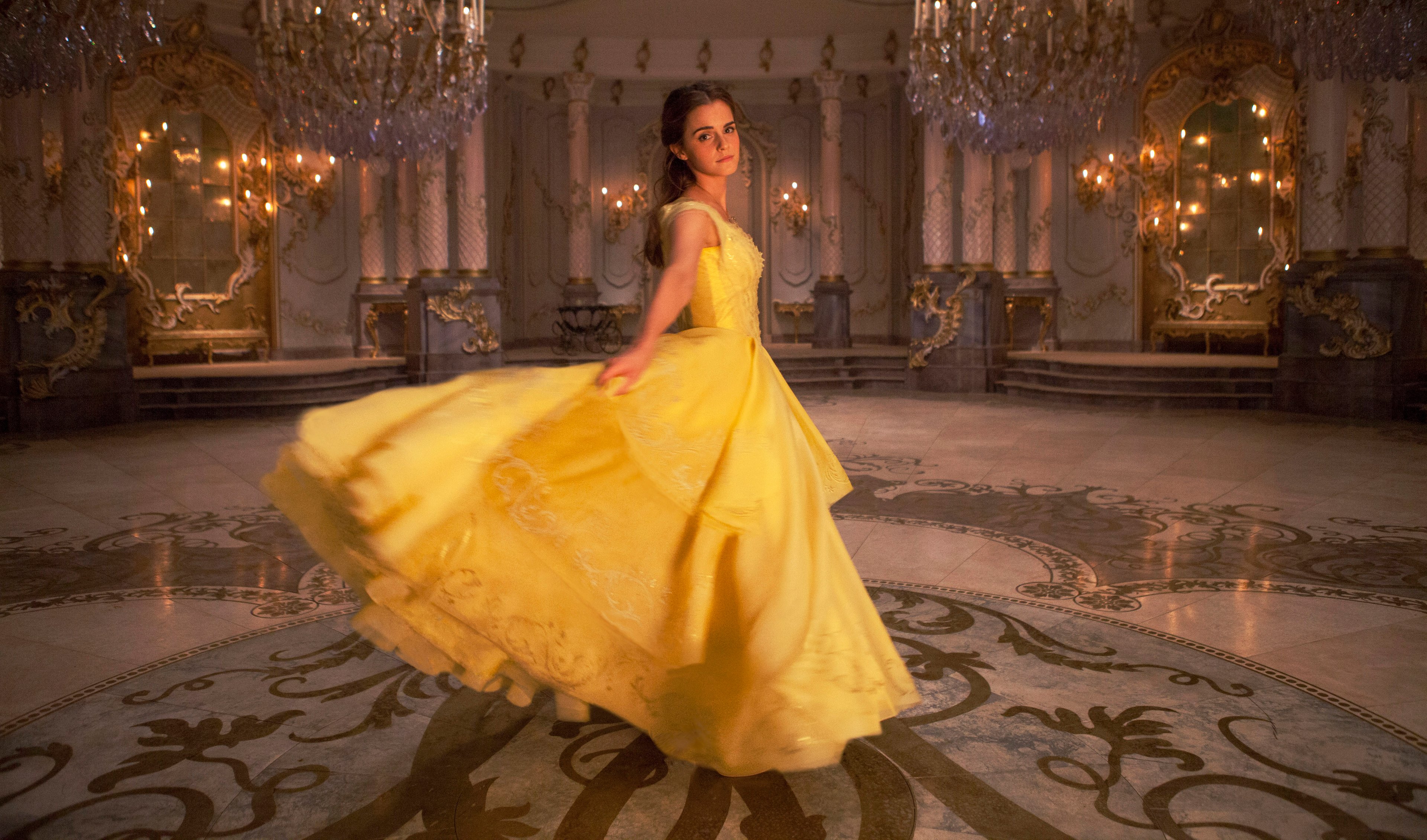 Emma Watson as Belle in a yellow gown in a ballroom for "Beauty and the Beast" movie.