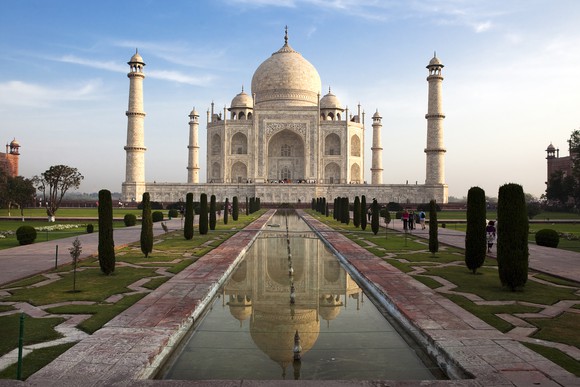 The Taj Mahal in India, a white palace with bulb-shaped dome on top and four smaller spires at each corner.
