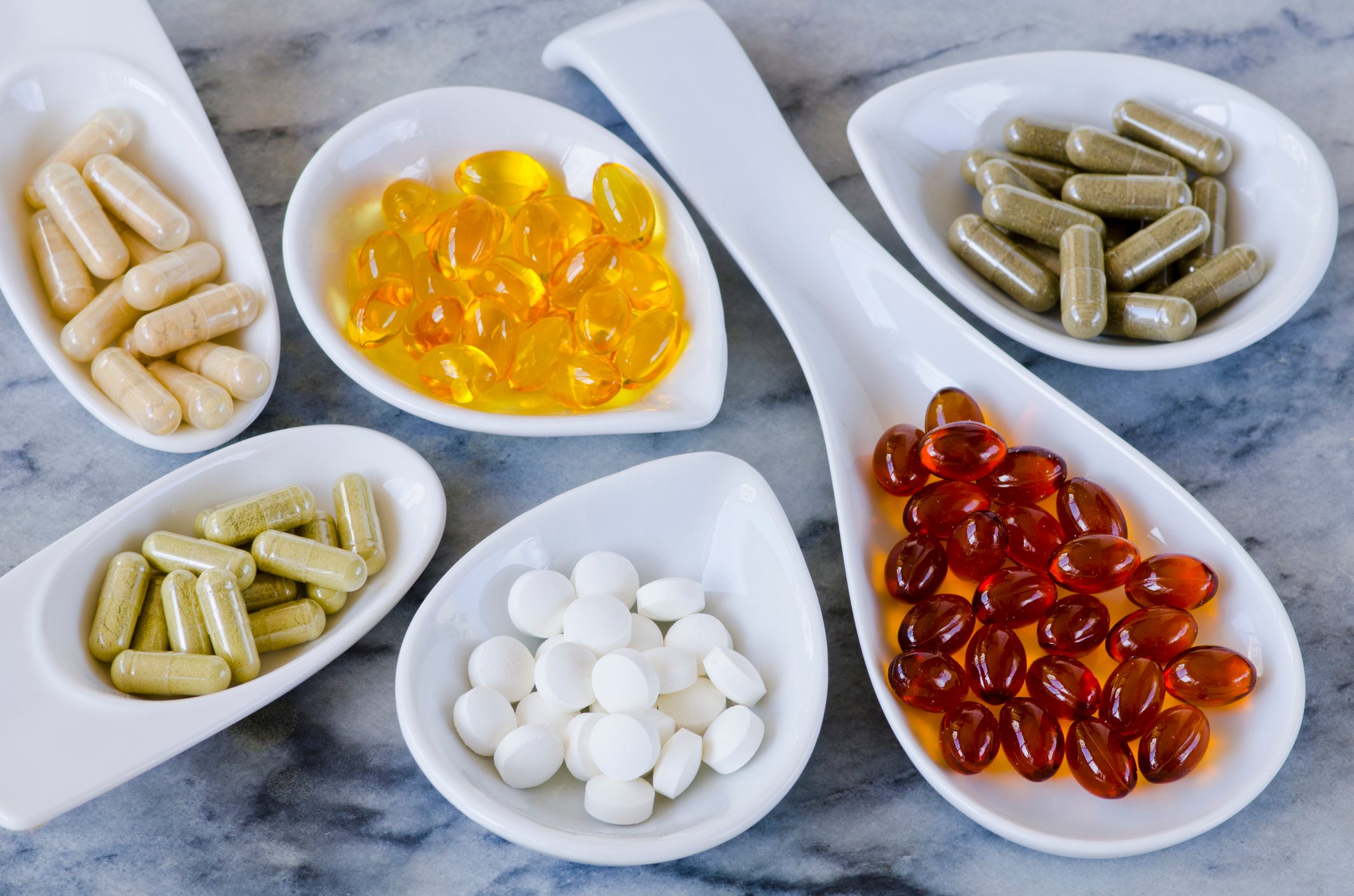 Nutrition supplements in bowls on a granite countertop. 