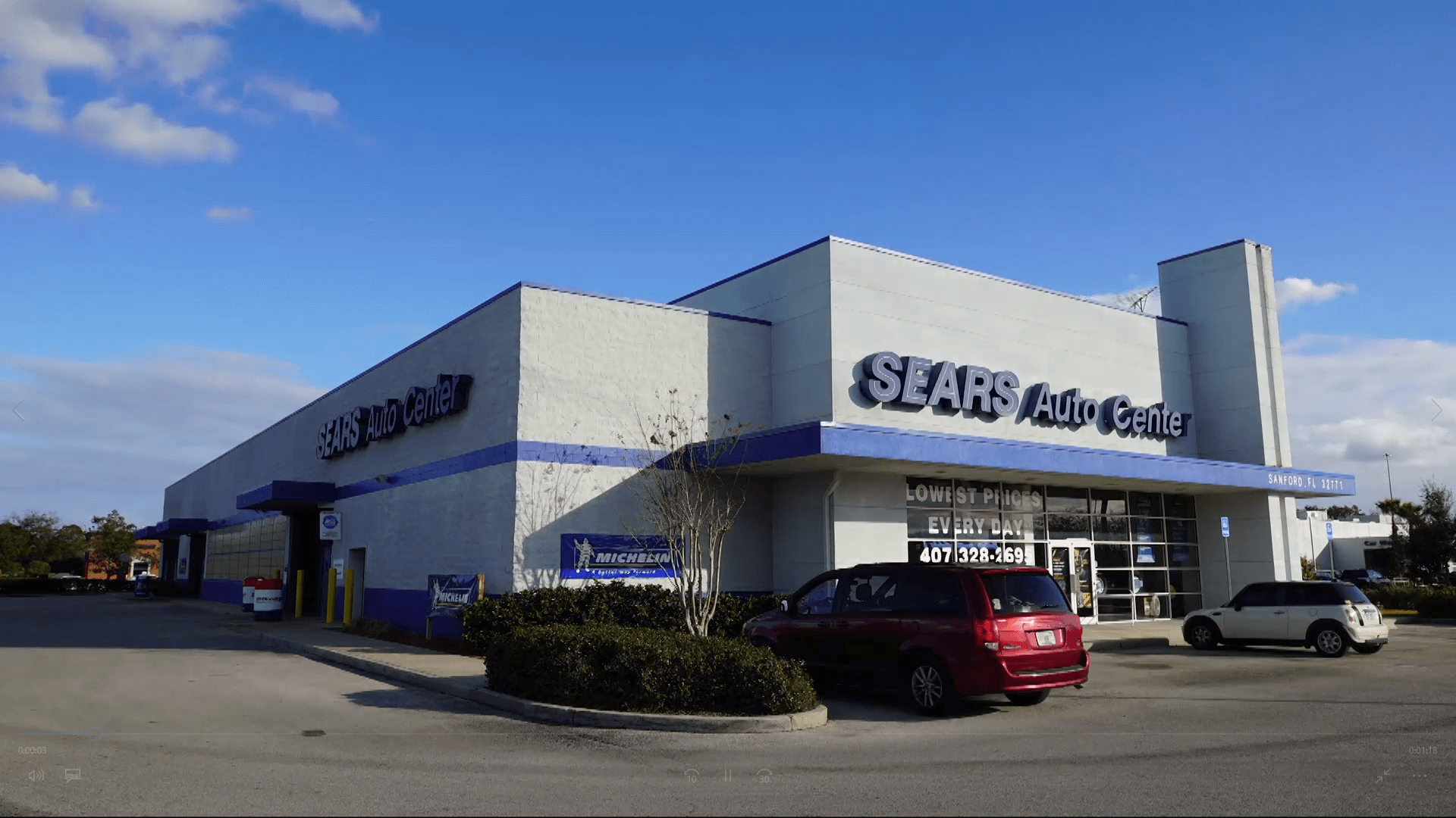 Sears auto center location with a couple of cars parked outside.