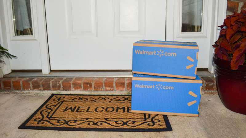 Two Walmart boxes stacked on a welcome mat